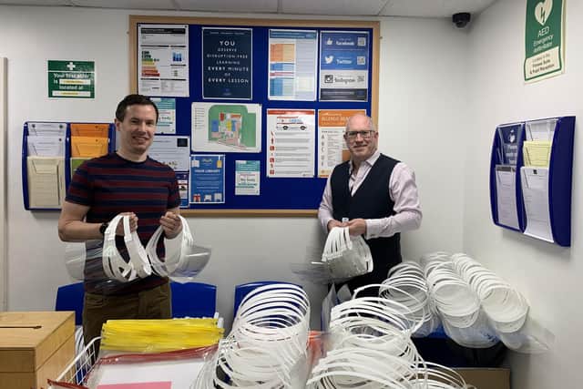 David Hedicker and Kyle Jonathan with some of the hundreds of face shields made at the school to be donated to critical workers.