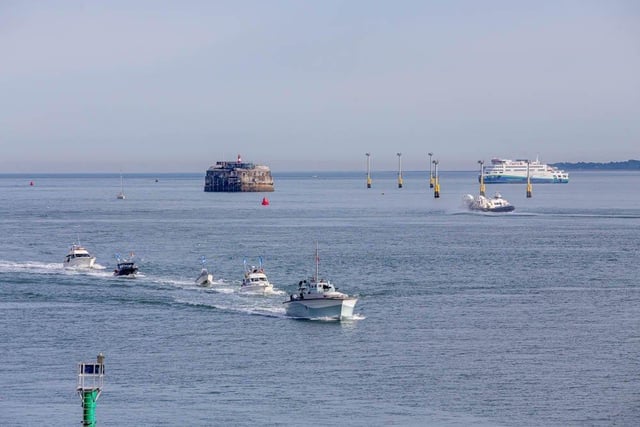 The boat parade entering Portsmouth Harbour to mark the beginning for Sea Angling Classic 2022 in Portsmouth on Thursday, June 16 2022- with a ferry and the hovercraft in the the background