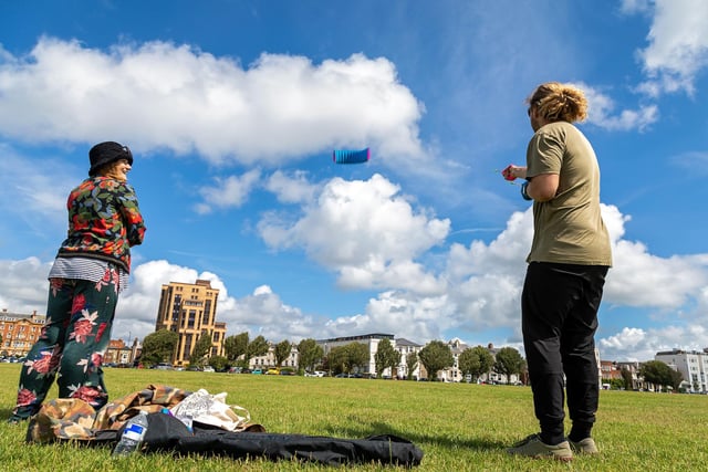 Bryony Mahoney (28) watches Josh Gent (27) fly his kite in the brisk winds at the kite festival. Picture: Mike Cooter (070821)