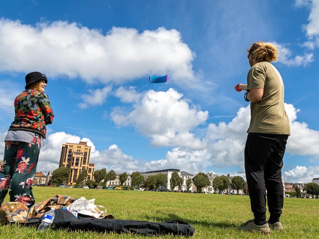 Bryony Mahoney (28) watches Josh Gent (27) fly his kite in the brisk winds at the kite festival. Picture: Mike Cooter (070821)