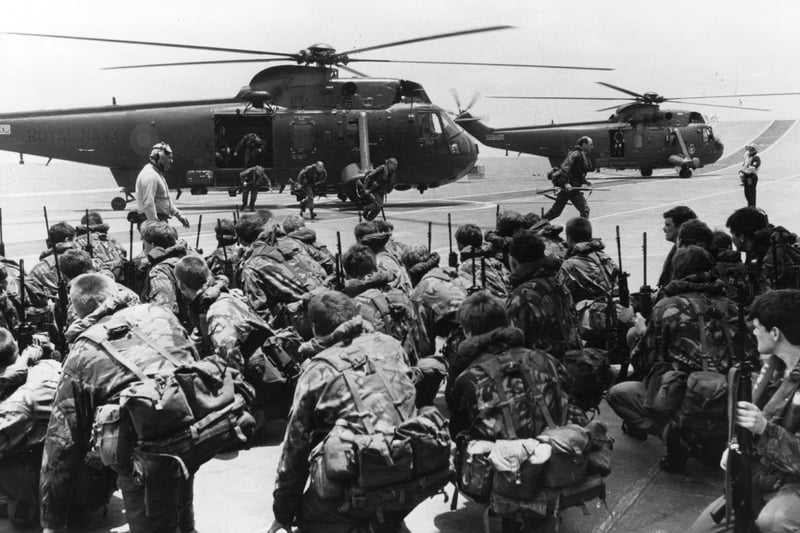 A view of commandos being lifted from the decks of HMS Hermes and HMS Invincible to be transferred by Westland Sea King helicopters to other ships while two carriers forge ahead to the Falkland Islands from Ascension Island.