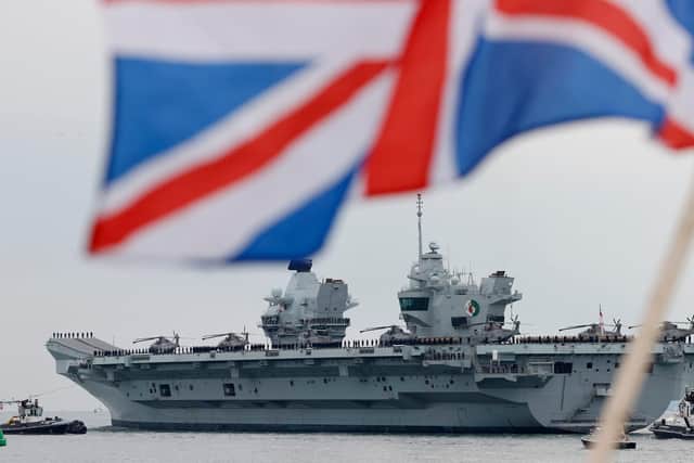 HMS Queen Elizabeth aircraft carrier leaves Portsmouth Naval Base on the south coast of England, on May 1, 2021, to take part in exercises off Scotland before heading to the Indo-Pacific region. - The HMS Queen Elizabeth aircraft carrier will leave Portsmouth later to take part in exercises off Scotland before heading to the Indo-Pacific region for her first operational deployment. Accompanied by six royal navy ships, a submarine and carrying eight RAF and 10 US jets she will replace HMS Ocean as the fleet flagship. (Photo by Adrian DENNIS / AFP) (Photo by ADRIAN DENNIS/AFP via Getty Images)