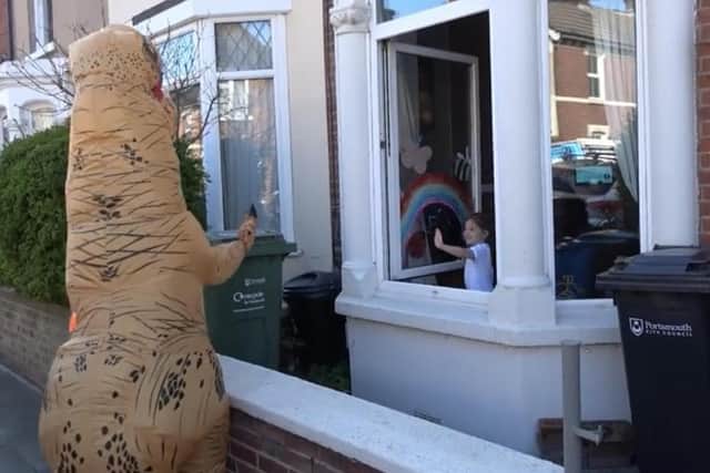 Hannah Pilcher, 29, of North End dresses up as a dinosaur to entertain children in Portsmouth during lockdown. Here she is pictured waving at a child in North End.