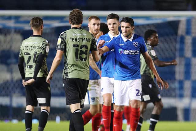 Gareth Evans fist bumps with Colchester players after Pompey's 2-0 win on Tuesday. Picture: Joe Pepler
