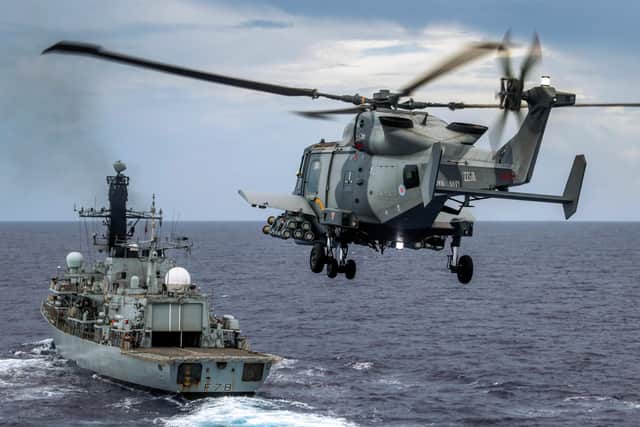 Pictured: HMS Defender's Wildcat HMA Mk 2 helicopter conducts a fly past HMS Kent with her Martlet wings attached whilst in the Indo-Pacific region.