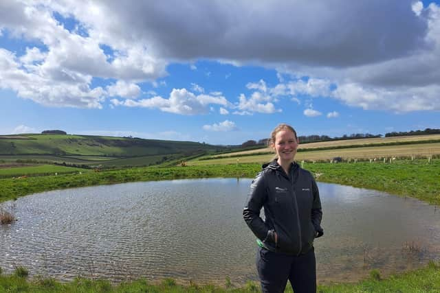 Park ranger Sophie Brown next to a restored dew pond near Arundel.  

Jeff Travis/PA Wire