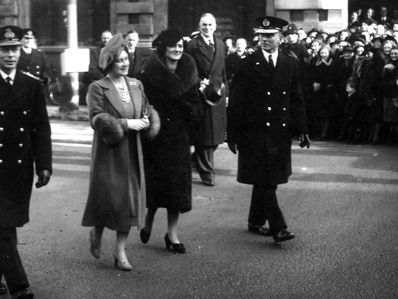 King George VI and Queen Elizabeth walking down a bomb damaged street in Portsmouth with Lord Mayor Sir Denis Daley and local dignitaries and military personnel. In the background are members of the Civil Defence. Picture: Portsmouth Museums and Records Service