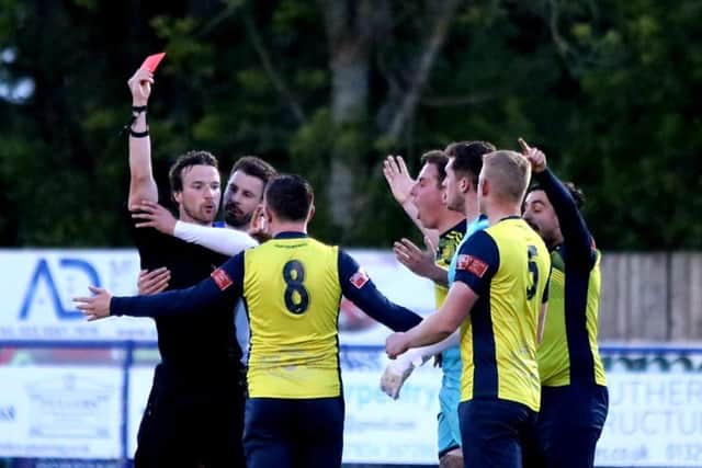 Referee Jordan McRitchie shows Moneyfields' Callum Glen (8) a first half red card. Picture by Tom Phillips