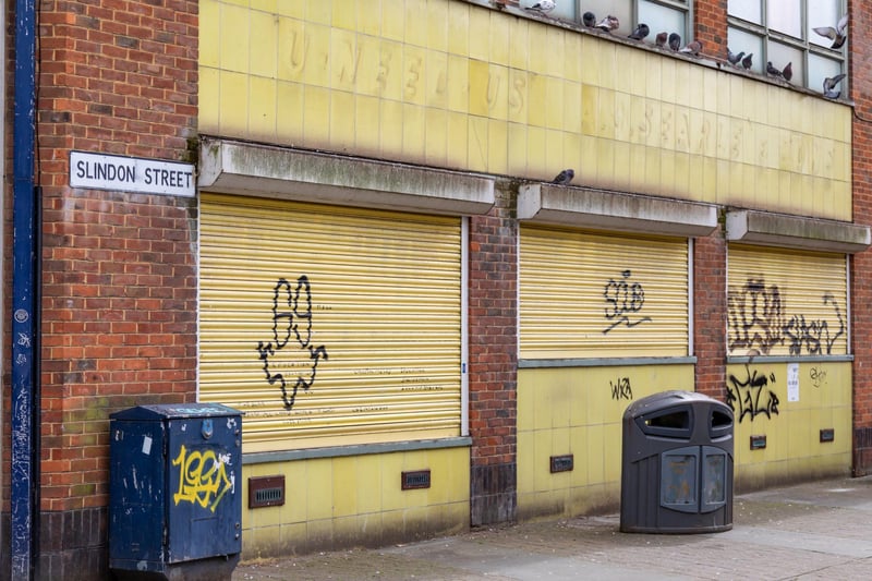 Graffiti on the shutters of the now-closed U-Need-Us shop on the corner of Arundel Street and Slindon Street
