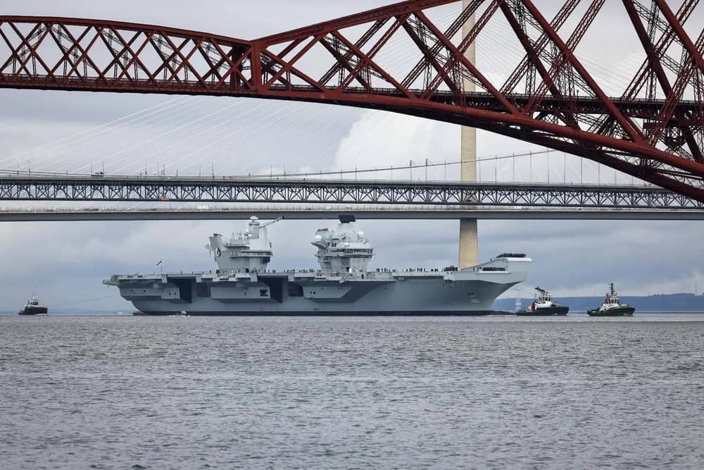 HMS Queen Elizabeth leaving Rosyth in Fife, Scotland, and sailing under the Forth bridge. She is due to return home to Portsmouth on July 30.