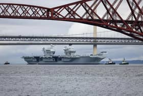 HMS Queen Elizabeth leaving Rosyth in Fife, Scotland, and sailing under the Forth bridge. She is due to return home to Portsmouth on July 30.