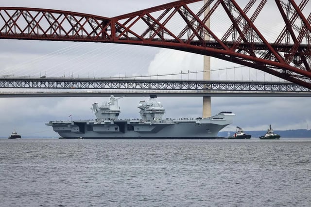 HMS Queen Elizabeth leaving Rosyth in Fife, Scotland, and sailing under the Forth bridge. She is due to return home to Portsmouth on July 30.