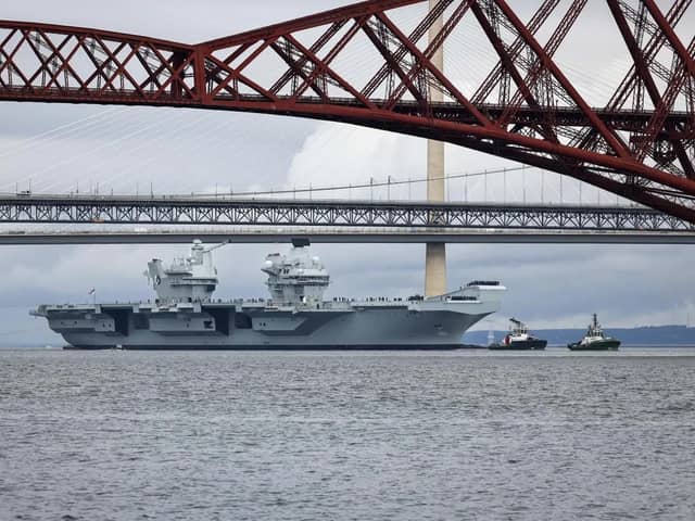 HMS Queen Elizabeth leaving Rosyth in Fife, Scotland, and sailing under the Forth bridge. She is due to return home to Portsmouth on July 30.