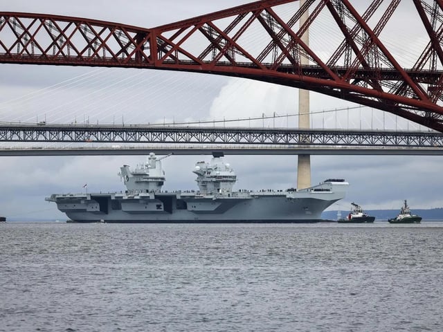 HMS Queen Elizabeth leaving Rosyth in Fife, Scotland, and sailing under the Forth bridge. She is due to return home to Portsmouth on July 30.