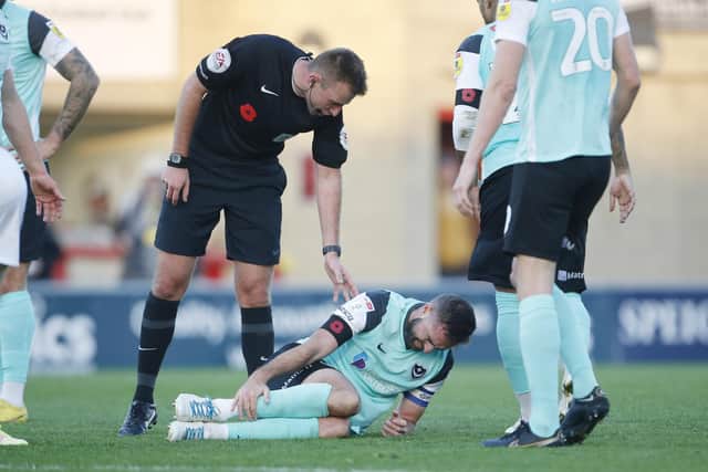 Referee Adam Herczeg checks on Clark Robertson after the Pompey captain picked up an ankle injury in the Blues' 1-1 draw at Morecambe
