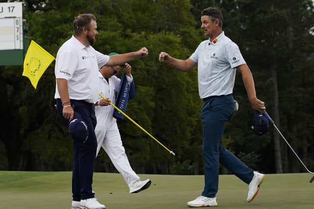 Justin Rose, right, is congratulated by Shane Lowry on the 18th hole after their first round at the Masters in Augusta. Picture: AP/David J. Phillip.