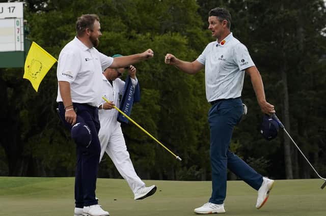 Justin Rose, right, is congratulated by Shane Lowry on the 18th hole after their first round at the Masters in Augusta. Picture: AP/David J. Phillip.