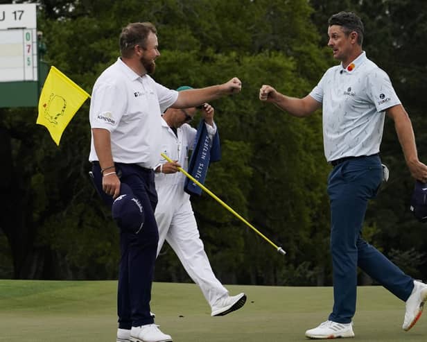 Justin Rose, right, is congratulated by Shane Lowry on the 18th hole after their first round at the Masters in Augusta. Picture: AP/David J. Phillip.