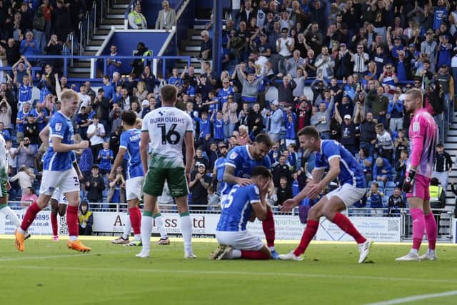 Regan Poole's Pompey team-mates celebrate his winner against former club Lincoln. Picture: Barry Zee,