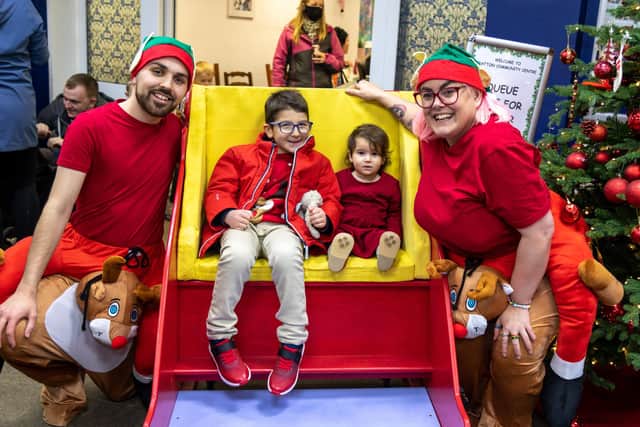 Elves Alex Weedon (22) and Sammy Thompson (30) with Mario Moya (6) and sister Valeria (17 months) in the sleigh donated by Men In Sheds.. Picture: Mike Cooter (111221)