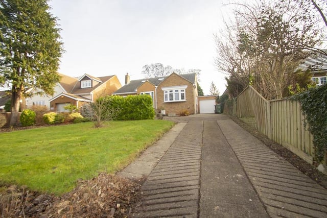 The large driveway leads to a single garage.