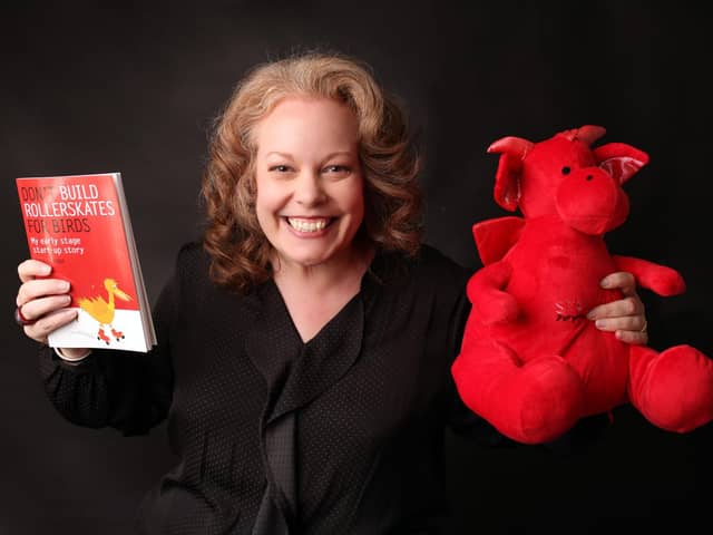 Becky Lodge, founder of Startup Disruptors with her book and company mascot, Den the Dragon