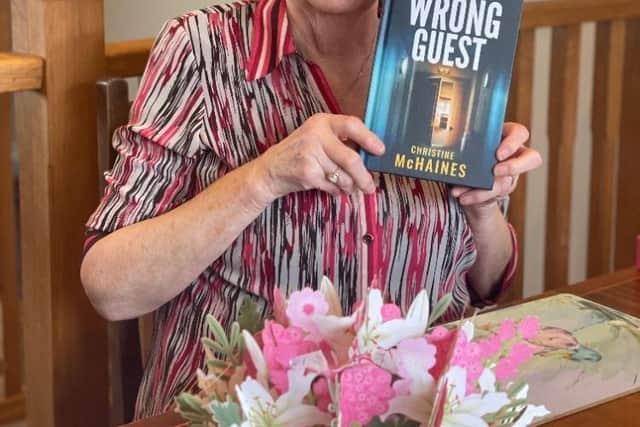 Christine McHaines with her new book, The Wrong Guest