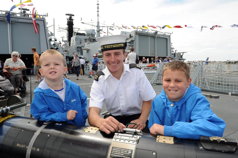 Navy Days 2010 at the Portsmouth Naval Base. Pictured onboard HMS Westminster leaning on a torpedo are brothers Harlee Cooper 3 and Joe Cooper 10 with ET Luke Wills. 30th July 2010. Picture: Paul Jacobs  102427-30