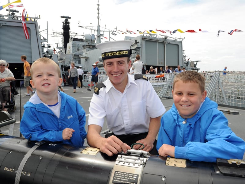 Navy Days 2010 at the Portsmouth Naval Base. Pictured onboard HMS Westminster leaning on a torpedo are brothers Harlee Cooper 3 and Joe Cooper 10 with ET Luke Wills. 30th July 2010. Picture: Paul Jacobs 102427-30
