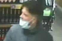 A suspected robber pictured with his face mask hanging below his nose and covering his chin. Photo: Hampshire police