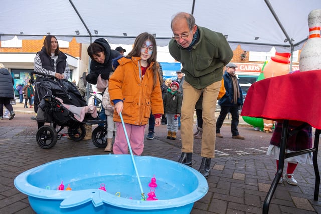 Locals braved the cold to celebrate the start of the Christmas festivites with a street party on Hayling Island on Saturday afternoon.Pictured - Youngster Phoebe Sadler, 6 with her grandad playing Hook-A-DuckPhotos by Alex Shute