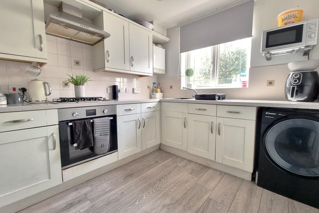 The kitchen features a comprehensive range of cream fronted wall and floor units, a single bowl stainless steel sink with mixer tap and drainer, four ring gas hob with electric oven under,  as well as space and plumbing for a washing machine.