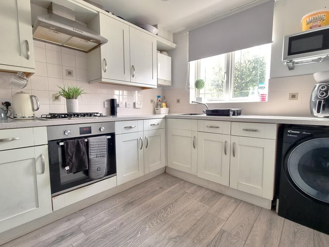 The kitchen features a comprehensive range of cream fronted wall and floor units, a single bowl stainless steel sink with mixer tap and drainer, four ring gas hob with electric oven under,  as well as space and plumbing for a washing machine.