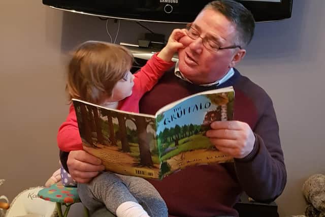 Andrew Oliver reads a bedtime story to his granddaughter Ruby.