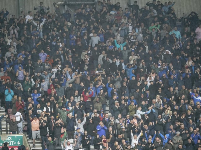 The Pompey fans celebrate in the away end at the DW Stadium