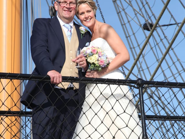 Martin and Angela posing on the historic stairwell of HMS Warrior on their wedding day, 2015.