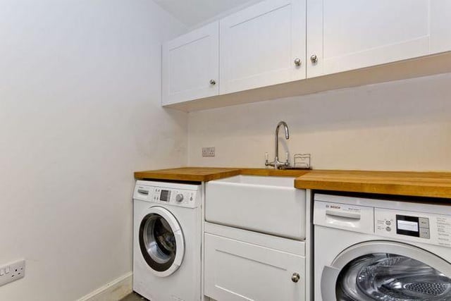 The separate utility room features a Belfast sink, further fitted storage and space for laundry appliances