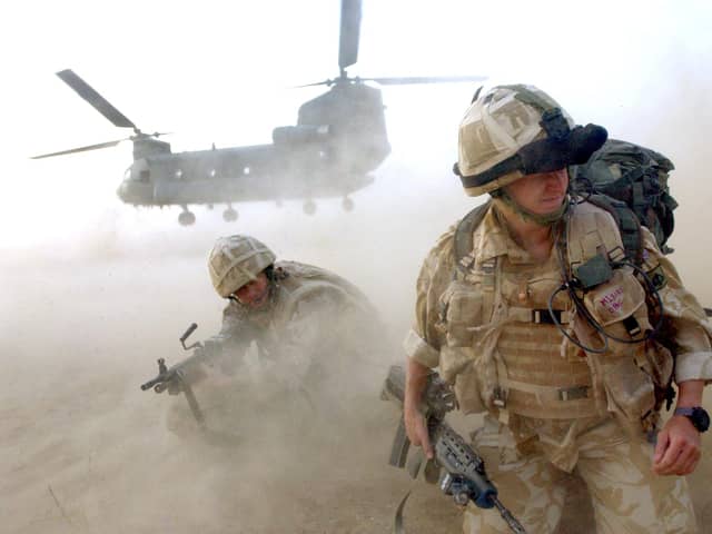 Sand and dust gets thrown up as No 3 Company he First Battalion The Grenadier Guards deploy out of an RAF Chinook helicopter in Helmand Province, southern Afghanistan. in July 2007. Picture: Sergeant Will Craig/Crown Copyright
