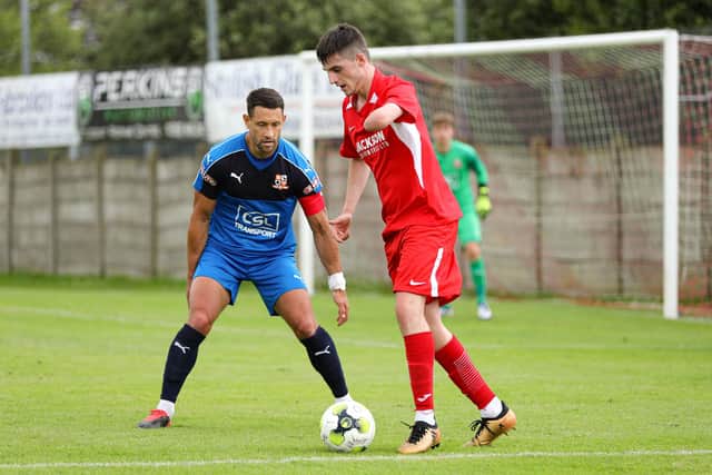 Horndean's Tommy Tierney (red) in action against Hartley Wintney. Picture: Chris Moorhouse