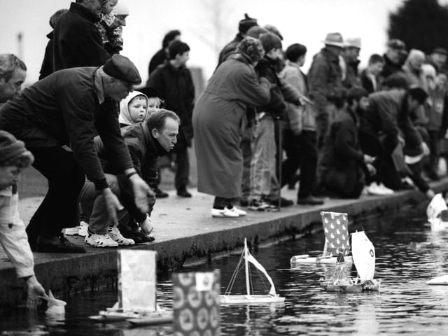 Competitors urge their boats on at the launch of the 1996 Gosport Model Yacht Club paper boat race at Walpole Park boating lake. The News PP3765