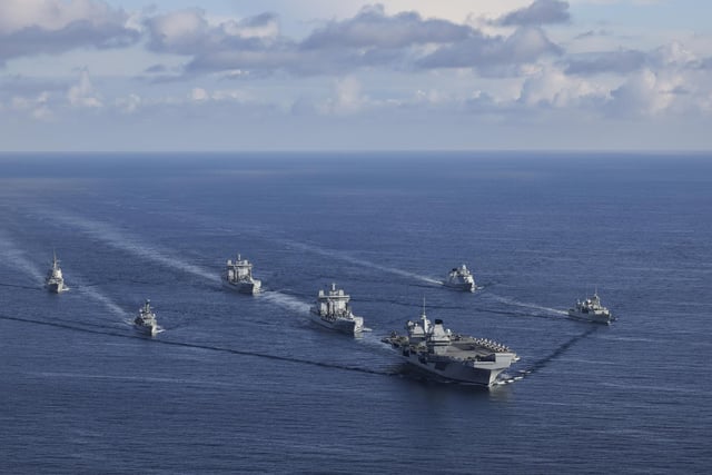 The UK CARRIER STRIKE GROUP during Exercise Joint Warrior. Aerial imagery of the UKCSG Task Group taken from a Merlin Mk2 of 814 Naval Air Squadron.Viewed from the front - HMS Prince of Wales; Row 2 (L-R) – HMS Portland, RFA Tidesurge, HMCS Charlottetown; Row 3 (L-R) – SNS Cristόbal Colόn, RFA Tidespring, HMDS Niels Juel.