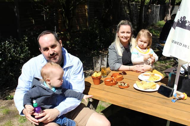 Ben Proctor holds little Preston while Emma Hicks sits with Neve in The Roebuck Inn, Wickham. Picture: Emily Turner