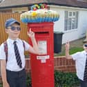 Thomas Smith, nine, and Noah Smith, five, with the postbox on the corner of Parkside and Queen Anne's Drive