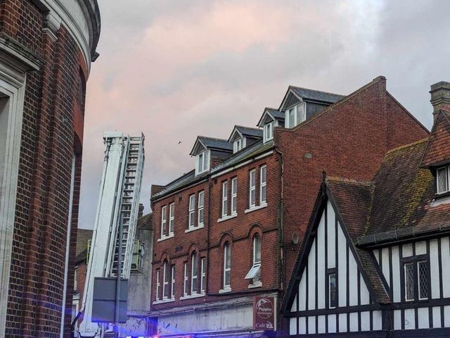 Firefighters fixing loose roof tiles and a sign above Poppins Cafe in North Street, Havant, on January 2.