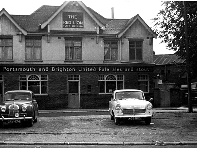 Austin Somerset and Standard Vanguard cars standing sentry at The Red Lion public house in Omega Street, Landport. Did you own one of the cars?