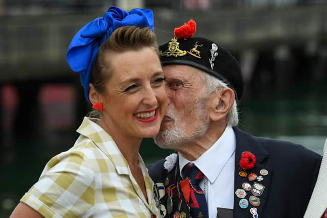 D-Day veteran Joe Cattini steals a kiss from an entertainer from The Charlalas after arriving at Portsmouth Historic Dockyard on June 06, 2021 Picture: Finnbarr Webster/Getty Images
