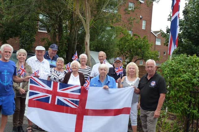 Armed Forces veterans and Trafalgar Court residents are angry at having to take down their White Ensign flag. Joe Ince, 76, is far left.