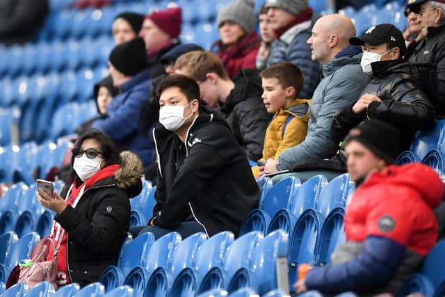 Fans wear disposable face masks prior to the Premier League match between Burnley FC and Tottenham Hotspur at Turf Moor.