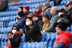 Fans wear disposable face masks prior to the Premier League match between Burnley FC and Tottenham Hotspur at Turf Moor.