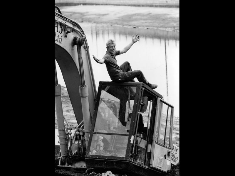 Self employed machine operator Tony Cussen stands in disbeleif on his 21 ton excavator, as it slowly embeds itself in the Haslar moat in Gosport, 1993. The News PP4779